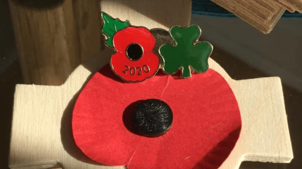 2000 Irish poppy pin next to a remembrance cross.